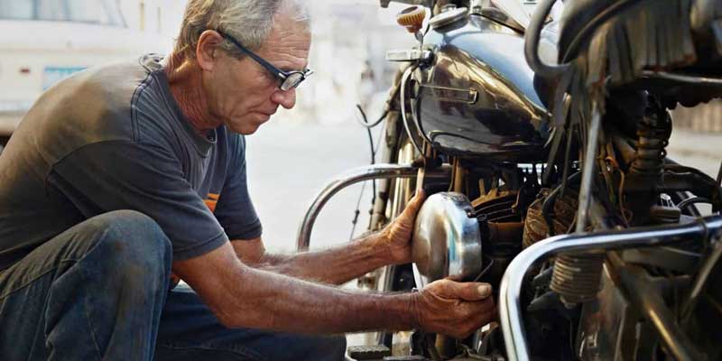 man fixing motorcycle