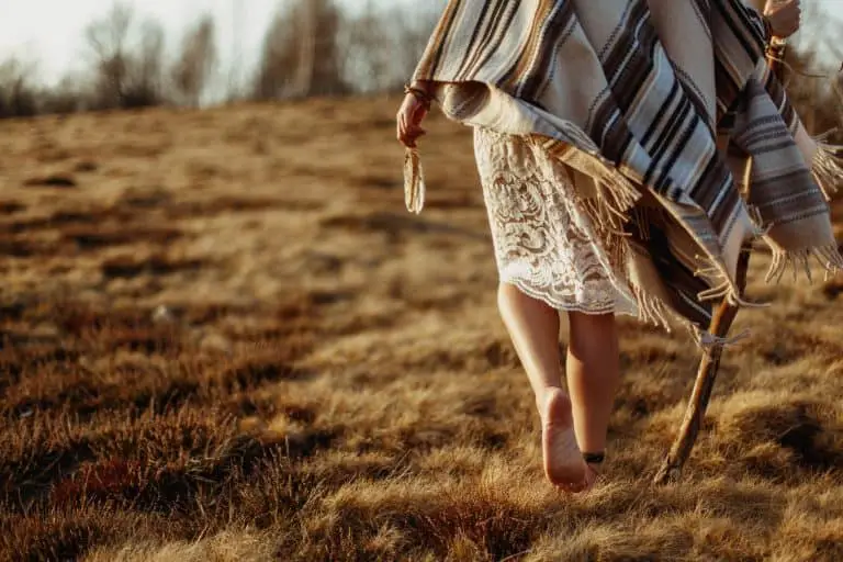 woman legs in native indian american boho dress walking in windy sunny mountains
