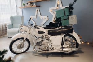 Cool retro motorcycle with Christmas presents. Motorcycle with gifts in decorated room