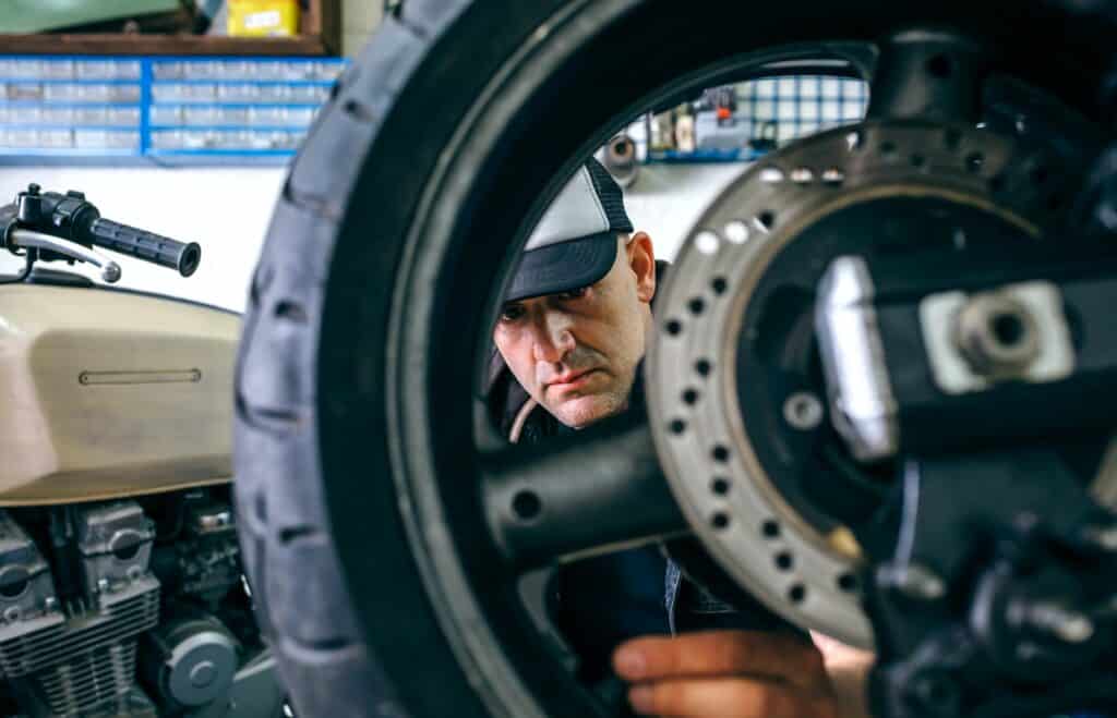 Mechanic fixing custom motorcycle wheel