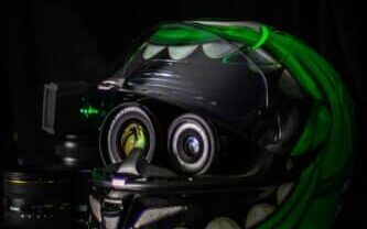 black aHelmet Mounting GoPro Cameras nd green full-face helmet on white wooden table